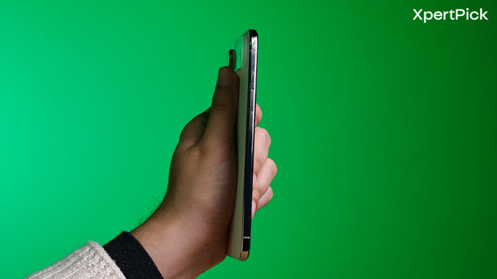 Apple iPhone Air side view showing the action button and volume controls, held in hand against a green backdrop. (Yetnesh Dubey / XpertPick)