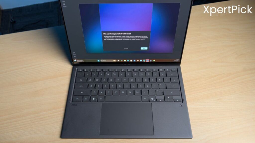 Top-down view of the ASUS ZenBook Duo showing the detachable keyboard, large touchpad, and the lower display running Windows interface on a wooden desk. (Source: Yetnesh Dubey / XpertPick)